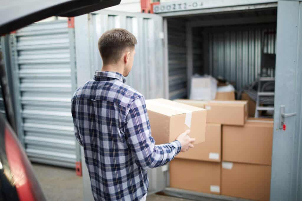 young men putting boxed in a storage container