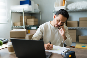 businessman on the phone writing something down