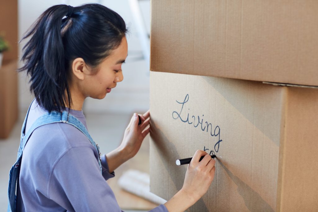 woman labeling moving boxe