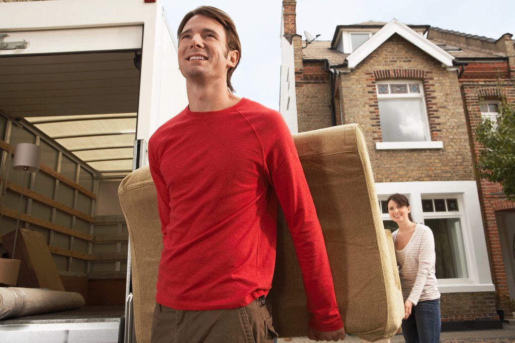 a couple putting their couch into storage