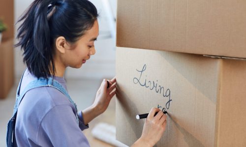 woman labeling moving boxe